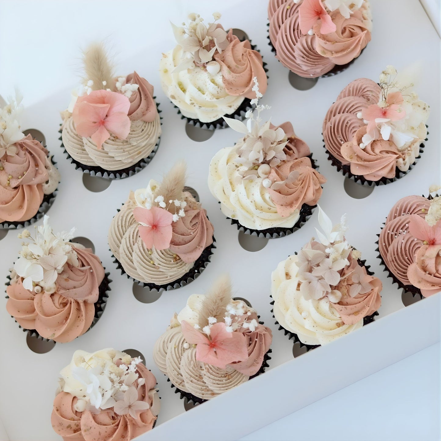Rustic boho cupcakes in latte, burnt orange and ivory. Decorated with delicate piping, flowers and sugar pearls