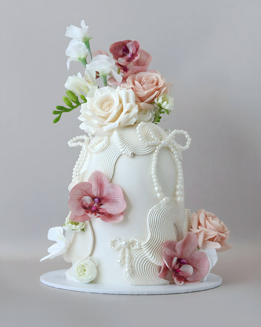 White dome cake with dusk florals and pearls bows