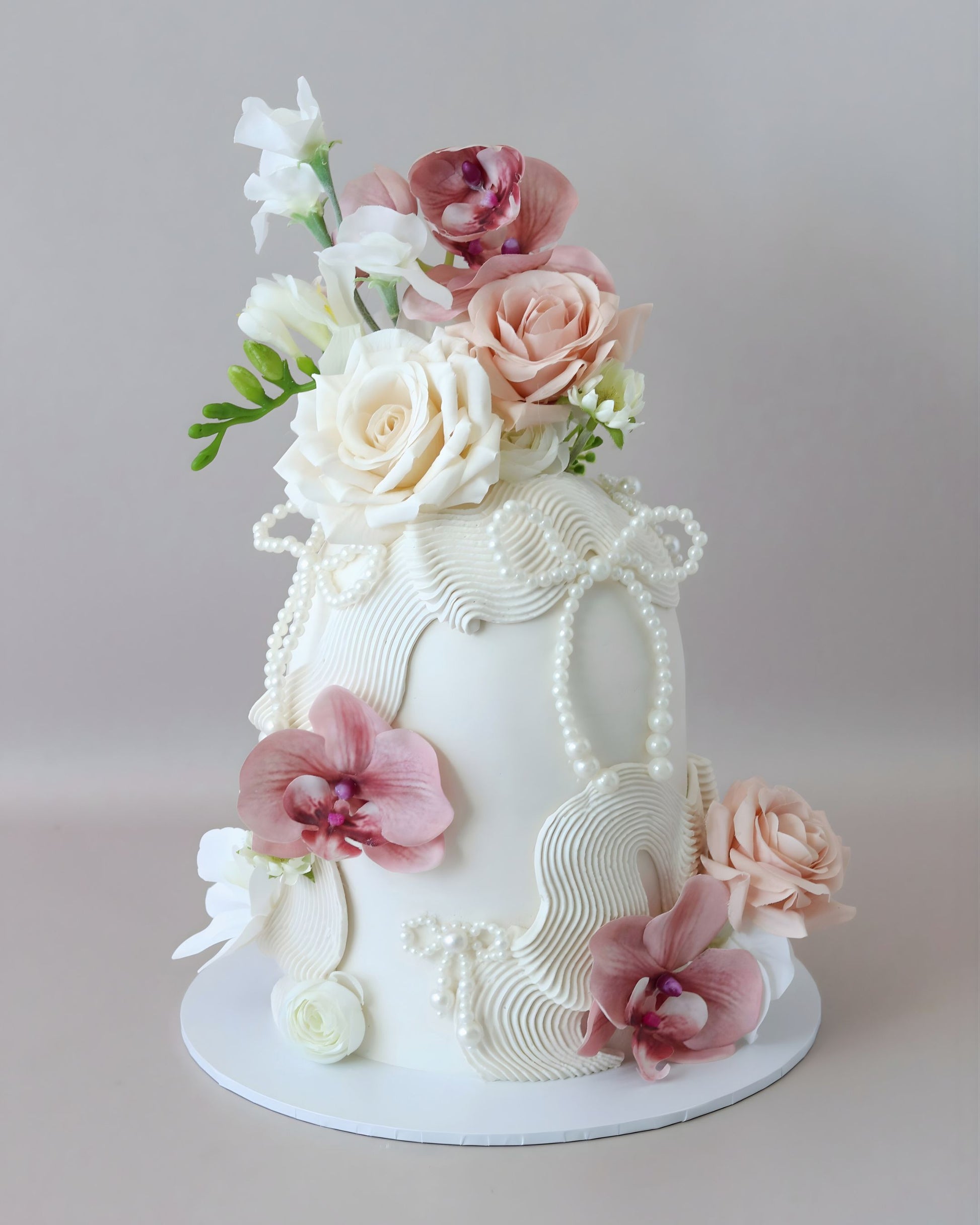White dome cake with dusk florals and pearls bows