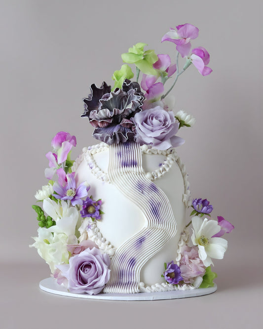 A modern and striking dome-shaped showstopper featuring a purple and green floral palette, organic squiggles and shimmering accents.
